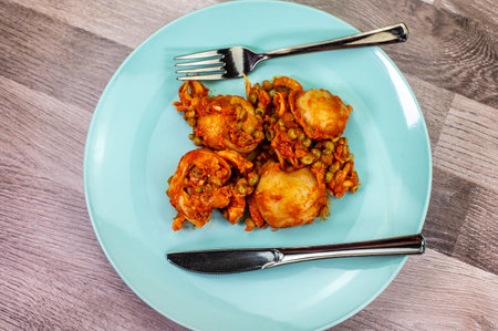 composition of plate with cuttlefish and peas on wooden table with glass cutleryの写真素材