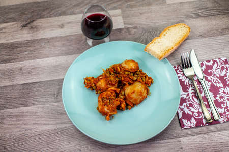 composition of plate with cuttlefish and peas on wooden table with glass cutleryの写真素材