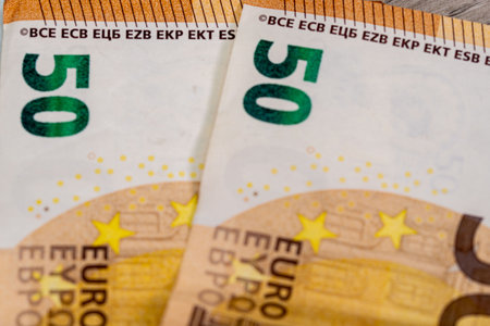 50 100 euro banknotes with calculator on wooden surface