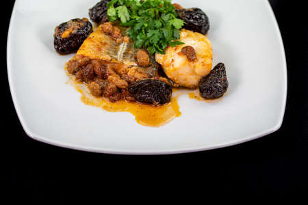 plate of sweet and sour cod on white plate and black backgroundの写真素材
