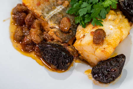 plate of sweet and sour cod on the table with parsleyの写真素材