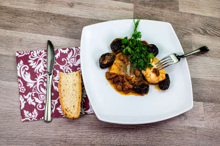 plate of sweet and sour cod on the table with parsleyの写真素材