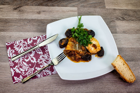 plate of sweet and sour cod on the table with parsleyの写真素材