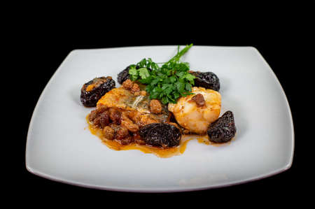 plate of sweet and sour cod on the table with parsleyの写真素材