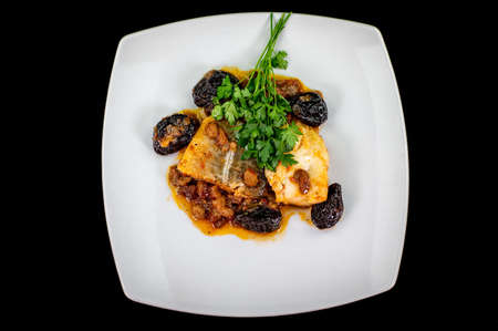 plate of sweet and sour cod on the table with parsleyの写真素材