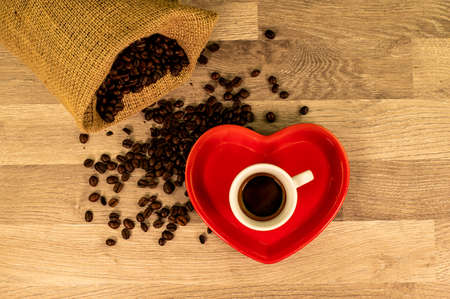 composition of coffee with grains and cups on wooden surface