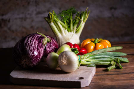 composition of vegetables with cutting board on wooden surfaceの写真素材