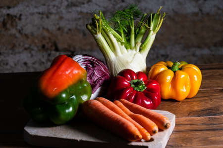 composition of vegetables with bark and cutting board on a wooden surfaceの写真素材