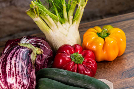 composition of vegetables with bark and cutting board on a wooden surfaceの写真素材