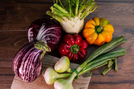 composition of vegetables with bark and cutting board on a wooden surfaceの写真素材