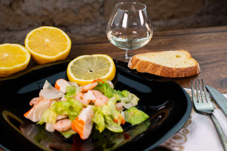 composition of a black plate with shrimp and surimi salad on a white satin backgroundの写真素材