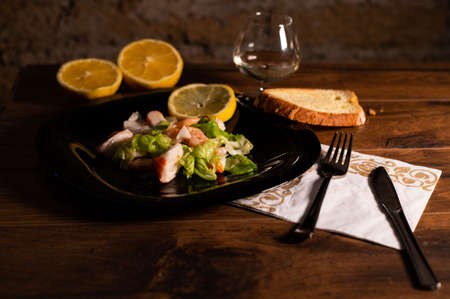 composition of a black plate with shrimp and surimi salad on a white satin backgroundの写真素材