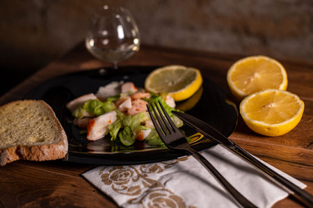 composition of a black plate with shrimp and surimi salad on a white satin backgroundの写真素材