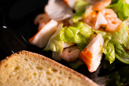 seafood salad composition with shrimps and surimi with cutlery and glass of white wine and lemonsの写真素材
