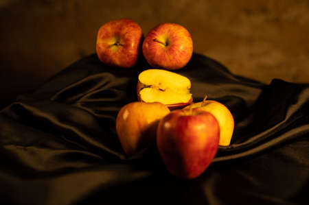 apples in golden basket on wooden countertopの写真素材