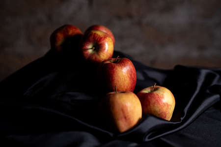apples in golden basket on wooden countertopの写真素材