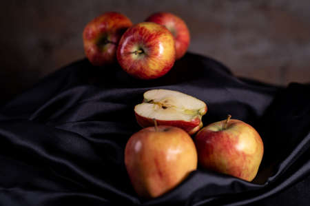 apples in golden basket on wooden countertopの写真素材