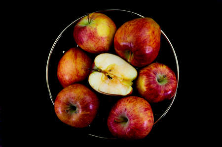 apples in golden basket on wooden countertopの写真素材