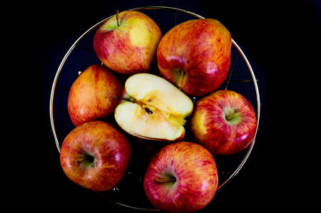 apples in golden basket on wooden countertopの写真素材