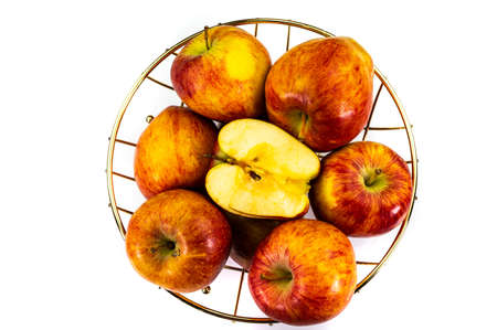 apples in golden basket on wooden countertopの写真素材