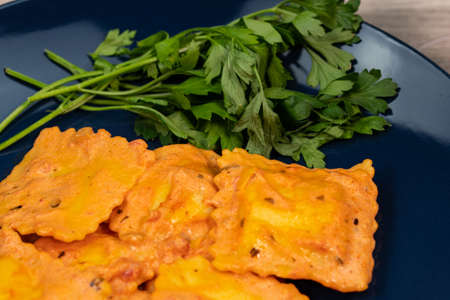 blue plate with fish ravioli with parsleyの写真素材