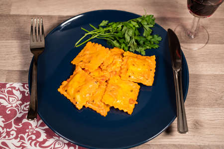 blue plate with fish ravioli with parsleyの写真素材