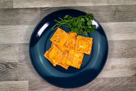 blue plate with fish ravioli with parsleyの写真素材