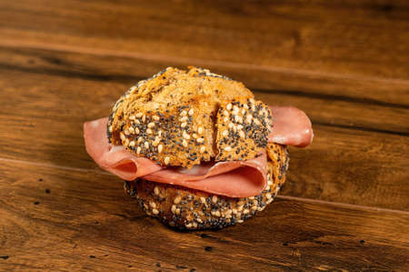 composition of sandwiches with salami and vegetables on a wooden surfaceの写真素材