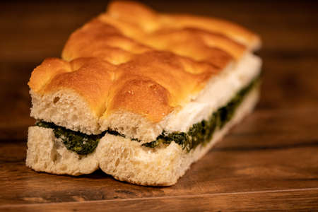 sandwich with salami and vegetables on a wooden surfaceの写真素材