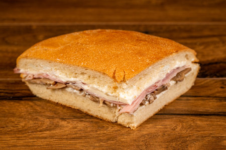 sandwich with salami and vegetables on a wooden surfaceの写真素材