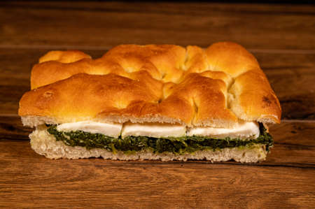 stuffed focaccia with cold cuts and vegetables on a wooden surfaceの写真素材
