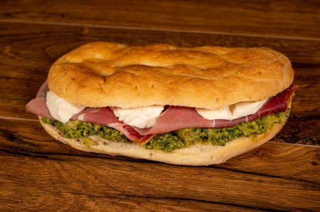 stuffed focaccia with cold cuts and vegetables on a wooden surfaceの写真素材