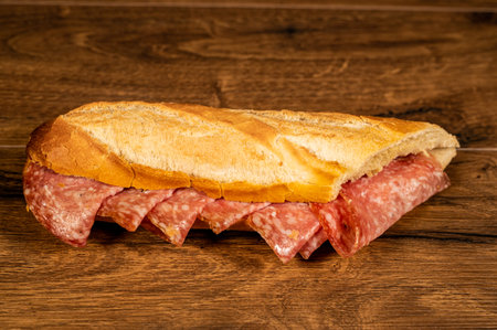 stuffed focaccia with cold cuts and vegetables on a wooden surfaceの写真素材