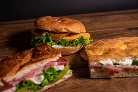 stuffed focaccia with cold cuts and vegetables on a wooden surfaceの写真素材