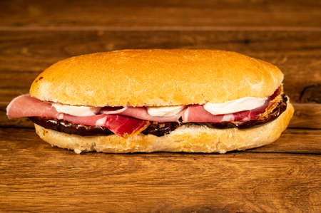 stuffed focaccia with cold cuts and vegetables on a wooden surfaceの写真素材