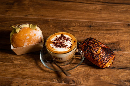 terni,italy october 26 2021:sweet croissants with cream and cappuccino on a wooden surfaceのeditorial素材