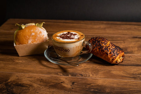 terni,italy october 26 2021:sweet croissants with cream and cappuccino on a wooden surfaceのeditorial素材