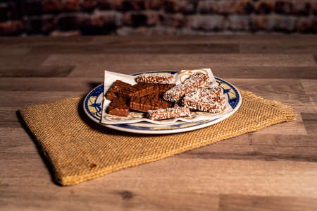 plate of chocolate chip cookies on a burlap tablecloth with wooden topの写真素材