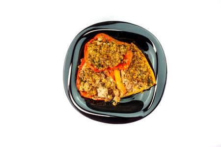 plate of peppers au gratin on wooden table set with cutlery and glass of wineの写真素材