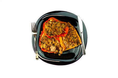plate of peppers au gratin on wooden table set with cutlery and glass of wineの写真素材