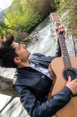 close up of boy with guitar in nature