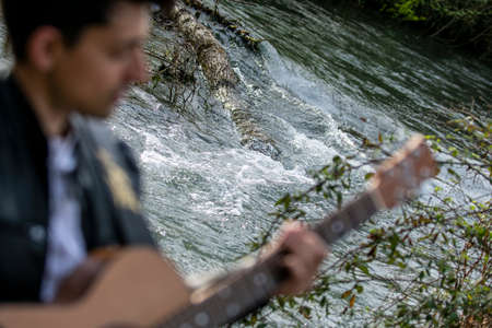 close up of boy with guitar on riverの写真素材