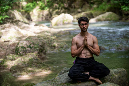 boy doing yoga in the woods bareback in tranquilityの写真素材