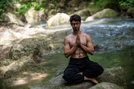 boy doing yoga in the woods bareback in tranquilityの写真素材