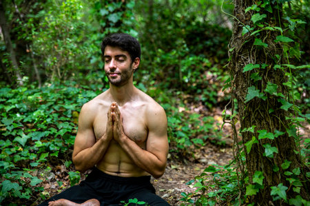 boy doing yoga in the woods bareback in tranquilityの写真素材