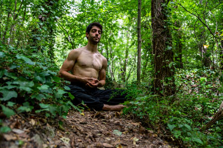 boy doing yoga in the woods bareback in tranquilityの写真素材
