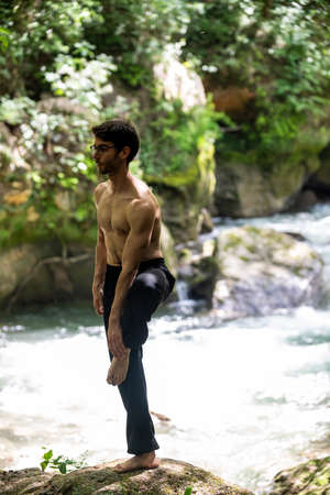boy doing yoga in the woods bareback in tranquilityの写真素材