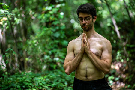 boy doing yoga in the woods bareback in tranquilityの写真素材