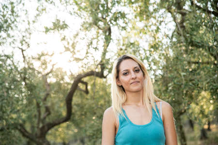 blonde girl smiling with nature background on a sunny day
