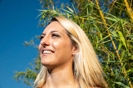blonde girl in the countryside smiles on nature backgroundの写真素材
